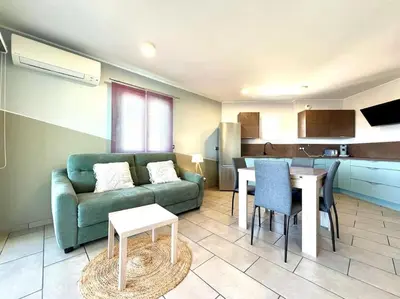 a living room with a green couch and a table at Appartement ALERIA 2/4 personnes in Aléria