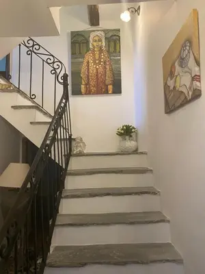 a staircase in a house with a painting on the wall at L'ALMA VIVA (Anciennement La Diligence) in Verdese