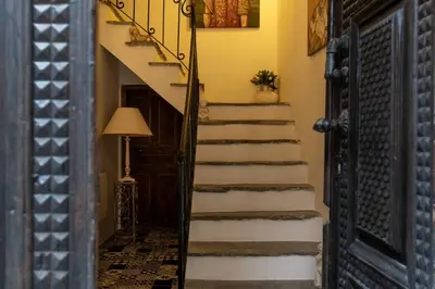 a hallway with stairs leading up to a door at L'ALMA VIVA (Anciennement La Diligence) in Verdese