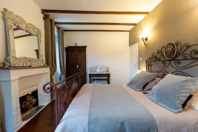 a bedroom with a bed with a fireplace and a mirror at L'ALMA VIVA (Anciennement La Diligence) in Verdese