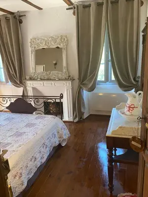 a bedroom with a bed and a mirror and a table at L'ALMA VIVA (Anciennement La Diligence) in Verdese