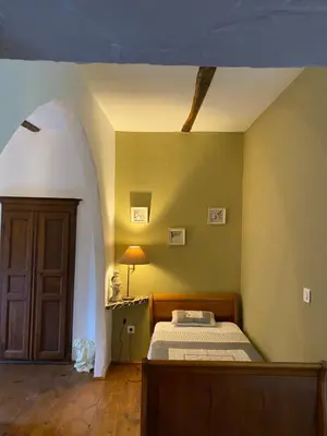 a bedroom with a bed and an arched doorway at L'ALMA VIVA (Anciennement La Diligence) in Verdese