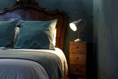 a bedroom with a bed and a lamp on a night stand at L'ALMA VIVA (Anciennement La Diligence) in Verdese