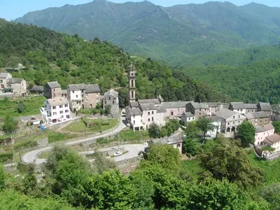 a village on a hill with mountains in the background at L'ALMA VIVA (Anciennement La Diligence) in Verdese