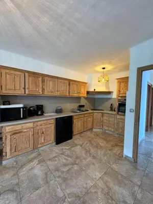 a kitchen with wooden cabinets and a black appliance at Appartement à 2 pas de la plage in Olmeto