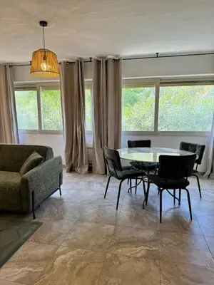 a living room with a table and chairs and a couch at Appartement à 2 pas de la plage in Olmeto