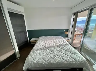 a bedroom with a bed and a balcony at Appartement Sole - vue golfe de Porto Vecchio in Porto-Vecchio