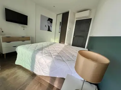a bedroom with a bed and a chair and a television at Appartement Sole - vue golfe de Porto Vecchio in Porto-Vecchio
