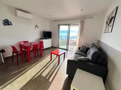 a living room with a couch and a table at Appartement Sole - vue golfe de Porto Vecchio in Porto-Vecchio