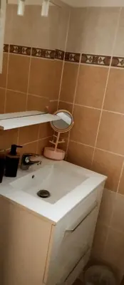 a bathroom with a white sink and a mirror at Villa les pieds dans l'eau in Borgo