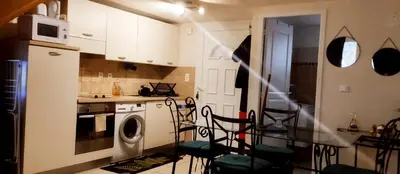 a kitchen with a table and chairs in a kitchen at Villa les pieds dans l'eau in Borgo