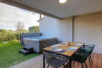 a patio with a table and chairs and a hot tub at Villa moderne Cala Rossa Bay Les Oceanides in Lecci