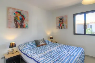a bedroom with a bed and two paintings on the wall at Villa moderne Cala Rossa Bay Les Oceanides in Lecci