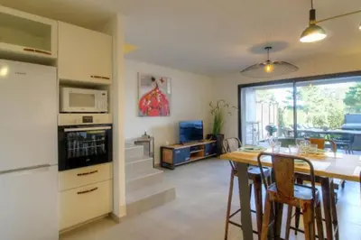 a kitchen and living room with a table and a microwave at Villa moderne Cala Rossa Bay Les Oceanides in Lecci