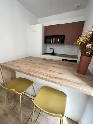 a kitchen with two chairs and a wooden counter at Joli appartement T1/Bis - Centre ville d’Ajaccio in Ajaccio
