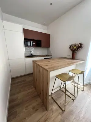a kitchen with a wooden counter and two stools at Joli appartement T1/Bis - Centre ville d’Ajaccio in Ajaccio
