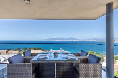 a dining room with a view of the ocean at Les Terrasses de l'Isolella - Vue mer et montagne in Pietrosella
