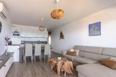 a living room with a couch and a table at Les Terrasses de l'Isolella - Vue mer et montagne in Pietrosella