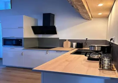 a kitchen with white cabinets and a counter top at chez lulu Appartement cosy. in Cozzano