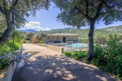 a bedroom with a bed and a chair and a window at San Quilico - Maison climatisée piscine vue mer in Aregno