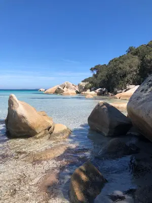 a group of rocks on a beach near the water at Villa pour 4 personnes proche Santa Giulia in Sotta