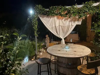 a table and chairs in a garden at night at Villa pour 4 personnes proche Santa Giulia in Sotta