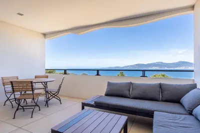 a living room with a couch and a table at Magadhja Fiurita - Appt climatisé - Vue mer in Pietrosella