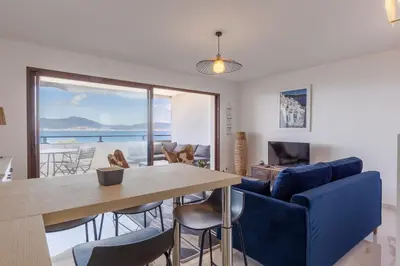 a dining room and living room with a table and chairs at Magadhja Fiurita - Appt climatisé - Vue mer in Pietrosella