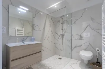 a bathroom with a shower and a toilet and a sink at Magadhja Fiurita - Appt climatisé - Vue mer in Pietrosella
