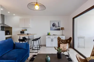 a living room with a blue couch and a table at Magadhja Fiurita - Appt climatisé - Vue mer in Pietrosella