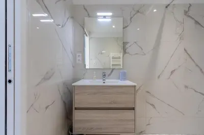 a bathroom with a sink and a mirror at Magadhja Fiurita - Appt climatisé - Vue mer in Pietrosella