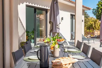 a table with bread and an umbrella on a patio at Casa Campa di Pinarello in Sainte-Lucie de Porto-Vecchio