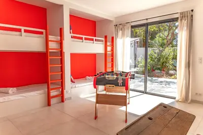 a bedroom with bunk beds and a red wall at Casa Campa di Pinarello in Sainte-Lucie de Porto-Vecchio