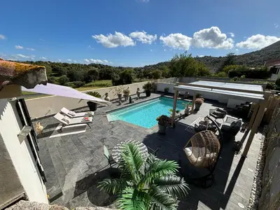 a view of a swimming pool with a house at Studio, piscine, 10 min des plages, Ajaccio, corse du sud, in Appietto