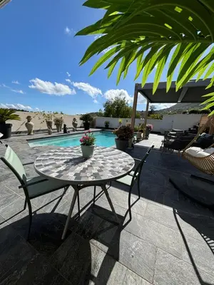 a patio with a table and chairs and a pool at Studio, piscine, 10 min des plages, Ajaccio, corse du sud, in Appietto