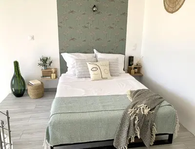 a bedroom with a bed with a green accent wall at Résidence 3 étoiles Pietra Gemina - Appartements de vacances, au calme, avec Piscine in Calenzana