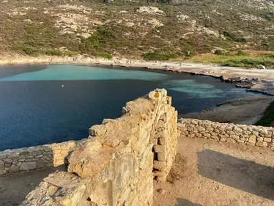 a stone wall next to a body of water at Résidence 3 étoiles Pietra Gemina - Appartements de vacances, au calme, avec Piscine in Calenzana