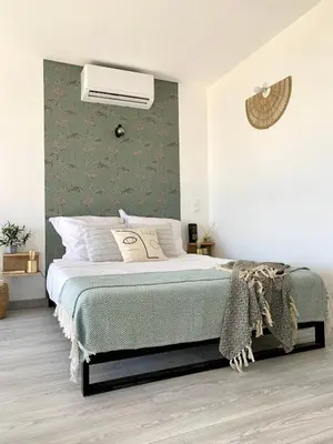 a bedroom with a bed with a green accent wall at Résidence 3 étoiles Pietra Gemina - Appartements de vacances, au calme, avec Piscine in Calenzana