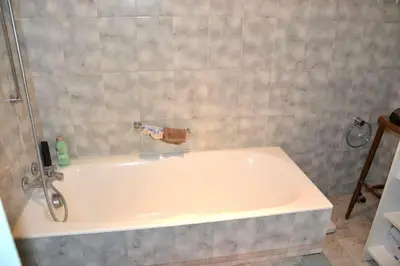 a white bath tub with a faucet in a bathroom at Appartement confortable à Ajaccio avec balcon in Ajaccio