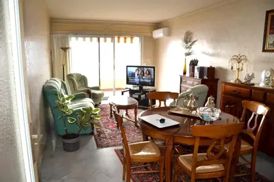 a living room with a dining room table and chairs at Appartement confortable à Ajaccio avec balcon in Ajaccio