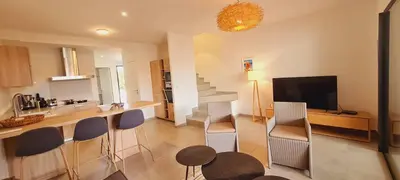 a kitchen and living room with a bar and chairs at Mini villa Bay, 6 pers, piscine, 400 m plage in Lecci