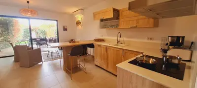a kitchen with wooden cabinets and a counter top at Mini villa Bay, 6 pers, piscine, 400 m plage in Lecci