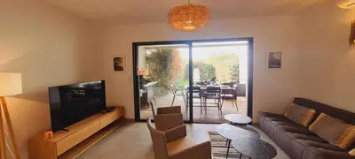 a living room with a couch and a television and a table at Mini villa Bay, 6 pers, piscine, 400 m plage in Lecci