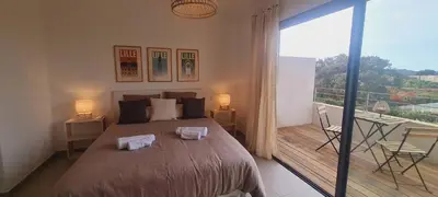 a bedroom with a large bed and a balcony at Mini villa Bay, 6 pers, piscine, 400 m plage in Lecci