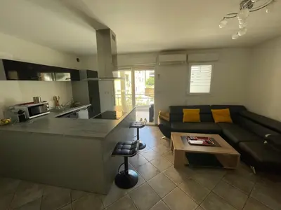 a living room with a couch and a kitchen at Immeuble le Mozart in Ajaccio