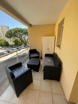 a balcony with two couches and two chairs at Immeuble le Mozart in Ajaccio