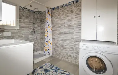 a bathroom with a washing machine and a shower at Awesome Home In Prunete With Wifi in Prunete