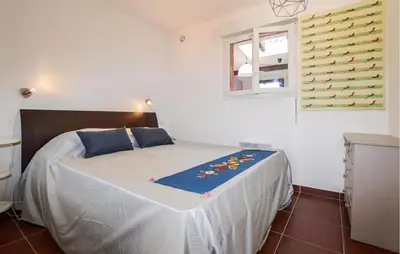 a bedroom with a bed with a blue blanket on it at Awesome Home In Prunete With Wifi in Prunete