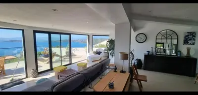 a living room with a couch and a clock at loft de standing 150 m2 vue mer,de 2 à 6 pers à Mare e Sole Plage d'argent Verghia in Coti-Chiavari