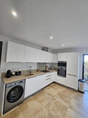 a kitchen with white cabinets and a washing machine at U Paradisu in Piana